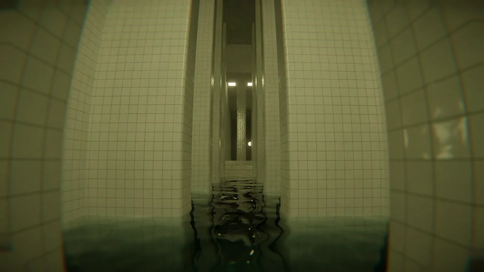 View from the water level of a narrow, tranquil indoor pool flanked by high white tiled walls. The perspective is centered down the length of the pool, creating a symmetrical image with the reflection of the water enhancing the sense of depth. The ceiling is not visible, but the light fixtures cast a subdued light, contributing to the serene and slightly moody atmosphere. The far end of the pool is in soft focus, with light reflecting off the water's surface.